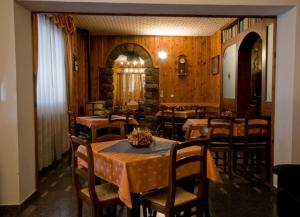 蒙蒂奥韦特拿破仑酒店的用餐室设有桌椅和木墙