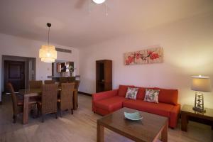 蓬塔卡纳Tot Punta Cana Apartments的客厅配有红色的沙发和桌子