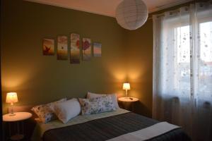贝内瓦吉恩纳Bene&Breakfast的一间卧室配有一张带两盏灯的床和一扇窗户。