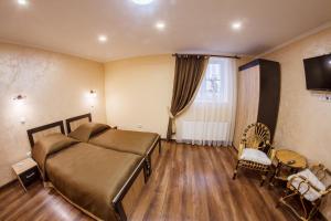 卡缅涅茨-波多利斯基Panorama Apart-Hotel的一间卧室配有一张床和一台电视,铺有木地板