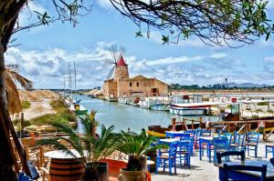 伯吉维奇Vigne al Vento的一个带蓝色椅子和风车的码头