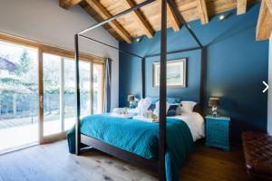 里雾诗亚历山德拉木屋的蓝色的卧室设有床和大窗户