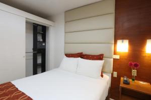 特古西加尔巴Minister Business Hotel的卧室配有白色的床和木墙