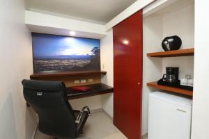 特古西加尔巴Minister Business Hotel的一间带椅子和墙上电视的房间