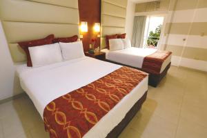 特古西加尔巴Minister Business Hotel的酒店客房设有两张床和窗户。