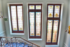 萨莫拉Hotel Alda Mercado de Zamora的楼梯上四扇彩色玻璃窗