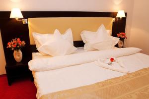 北马马亚-讷沃达里Pension Siera的酒店客房的床铺上装饰着玫瑰花