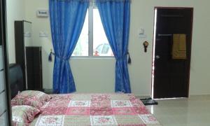日得拉日得拉克科基帕亚迪民宿的一间卧室配有床和蓝色窗帘的窗户