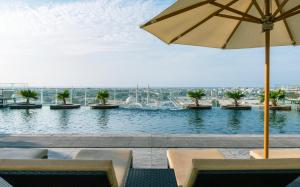 迪拜The Tower Plaza Hotel Dubai的一个带椅子和遮阳伞的游泳池