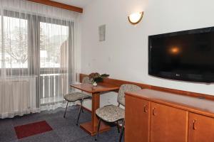 博希尼Hotel Tripič, restaurant and pizzeria的酒店的客房配备了书桌和平面电视。