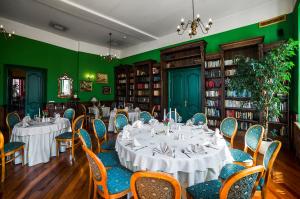 维尔纽斯莎士比亚精品酒店 的用餐室设有桌椅和绿色的墙壁