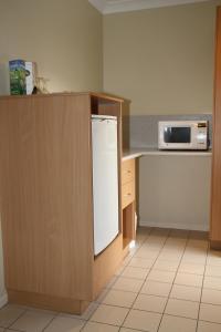 Gayndah盖恩达康特雷罗兹汽车旅馆的厨房配有白色冰箱和微波炉