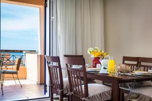 米尼亚Villas Cape的一间带桌椅的用餐室和一个阳台