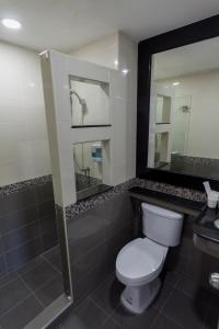 曼谷Q空间酒店的一间带卫生间、淋浴和镜子的浴室