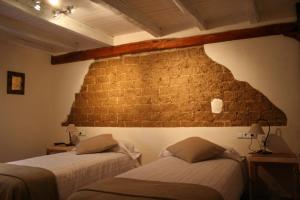 Dobro诺加拉乡村民宿的砖墙客房的两张床