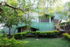 KoynanagarWind Chalet的院子里有树的绿色房子