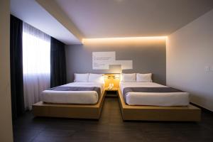 瓜达拉哈拉普尔拉中央酒店的小型客房 - 带2张床和窗户