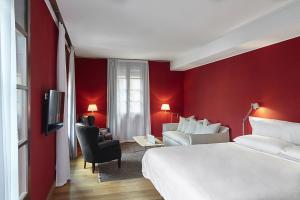 巴塞罗那Casa Camper Barcelona的酒店客房,设有白色的床和红色的墙壁