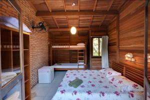 蜜岛Pousadinha的小木屋内一间卧室,配有一张床