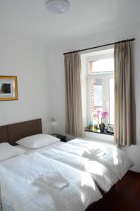 斯塔沃洛Le Baron Apartments的卧室设有一张白色大床和一扇窗户。