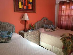 金斯敦天堂海滩酒店的一间卧室配有两张床和床头灯。