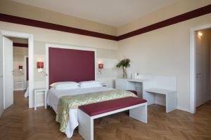 蒙特卡蒂尼泰尔梅全景大酒店的一间卧室配有一张床、一张桌子和一张桌子