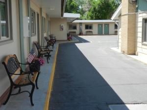 里弗顿Paintbrush Motel的建筑物旁人行道上的一排长椅