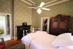 莫尔登棕榈屋住宿加早餐旅馆的卧室配有白色的床和吊扇