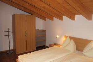 贝特默阿尔卑瓦卡蒂普旅舍的一间卧室配有一张床和一个木制橱柜
