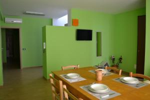 苏尔博b&b Appia Antica的一间设有木桌和绿色墙壁的用餐室