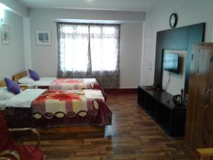 噶伦堡Aapas Residency的一间卧室配有一张床、一个梳妆台和一扇窗户。