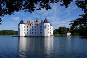 Jübek古斯酒店的一座大型白色城堡,位于水体上