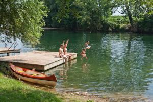 梅特利卡Holiday resort & camping Bela krajina - river Kolpa的一群在码头的水中玩耍的孩子