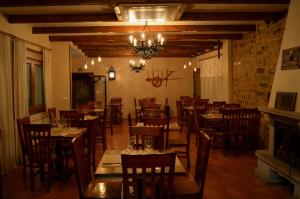 蒙福特·德·莱蒙斯Hotel Casa Reboiro的餐厅设有木桌、椅子和吊灯。