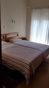 弗洛里纳费拉雷提酒店的一间卧室配有一张带条纹毯子的大床