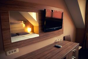 Trebnje奥帕拉酒店的卧室配有镜子和墙上的电视