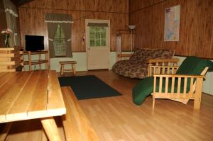 Fair PlayCarolina Landing Camping Resort Deluxe Cabin 4的带沙发、桌子和电视的客厅