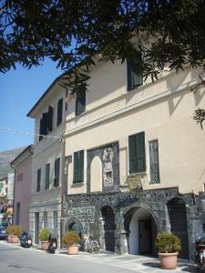 莱万托Ospitalia del Mare Hostel的街道上一座带绿色百叶窗的大型石头建筑