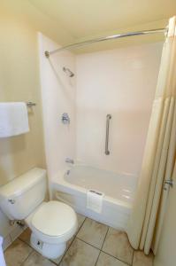 棕榈滩花园亚美利加汽车旅馆的浴室配有卫生间、浴缸和淋浴