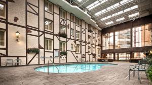 明尼阿波利斯诺曼底贝斯韦斯特套房酒店的一座大建筑,在庭院里设有一个游泳池