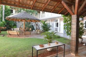 大坎普Hotel Pousada Mato Grosso的一个带桌子和遮阳伞的庭院