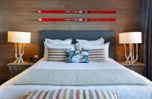 热克斯Chalet-Hôtel La Mainaz Restaurant & Resort的一间卧室配有一张带两盏灯和枕头的床。