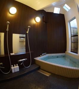 竹田赤川温泉スパージュ-Spaju的一间带按摩浴缸和两个淋浴的浴室