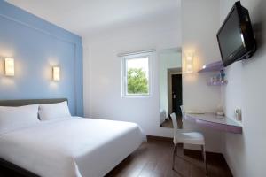 万隆万隆阿马瑞斯酒店的酒店客房设有白色的床和电视。