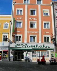弗克拉布鲁克奥尔哈恩餐厅城市酒店的一座高大的橙色建筑,前面有标志