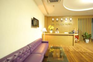 岘港红宫酒店的柜台前带紫色沙发的等候室