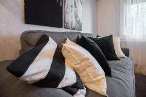 萨格勒布Hella Apartment的客厅的沙发上堆枕头