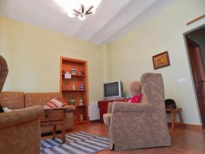 ZoritaCasa Rural La Perra Gorda的客厅配有沙发、椅子和电视