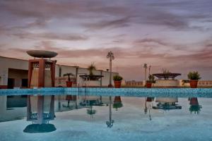 斋浦尔克拉里翁贝拉卡萨机场酒店的建筑物屋顶上的游泳池