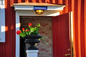 韦斯特罗斯Hem till Gården boutique hotel的门前装有红色花卉的花瓶